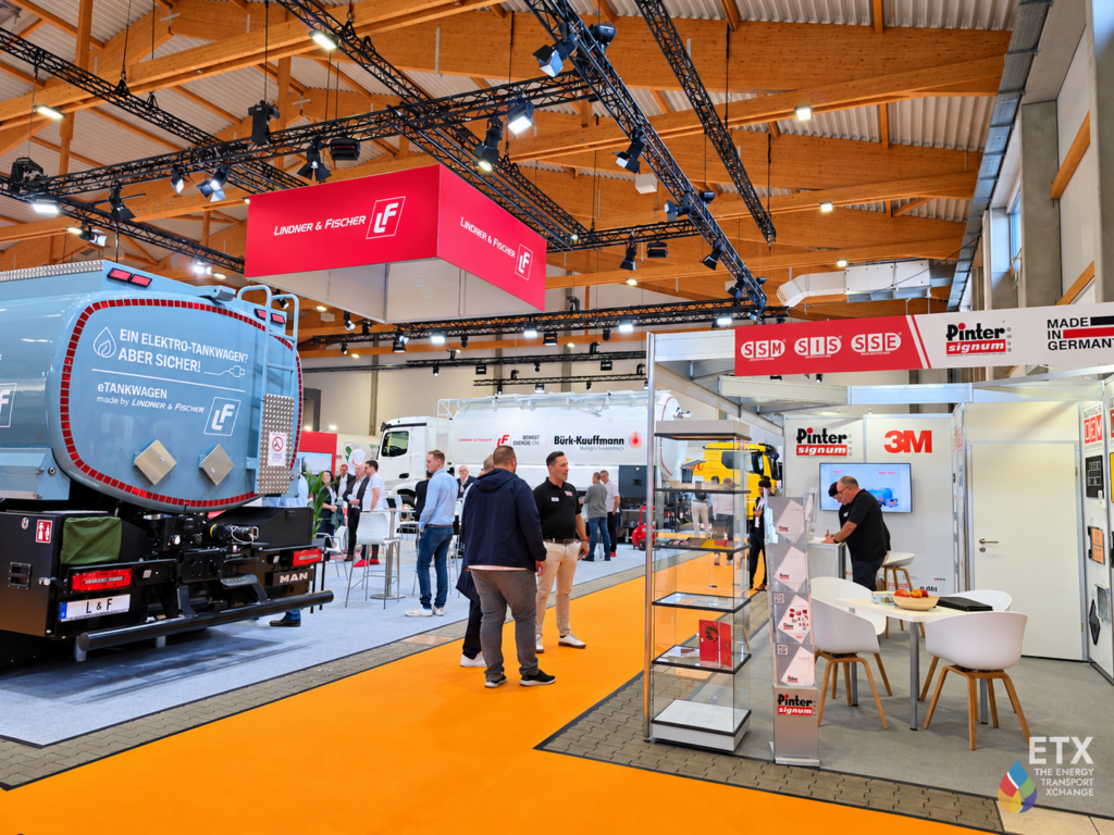 Ausstellungshalle mit Fahrzeugen und Messeständen
